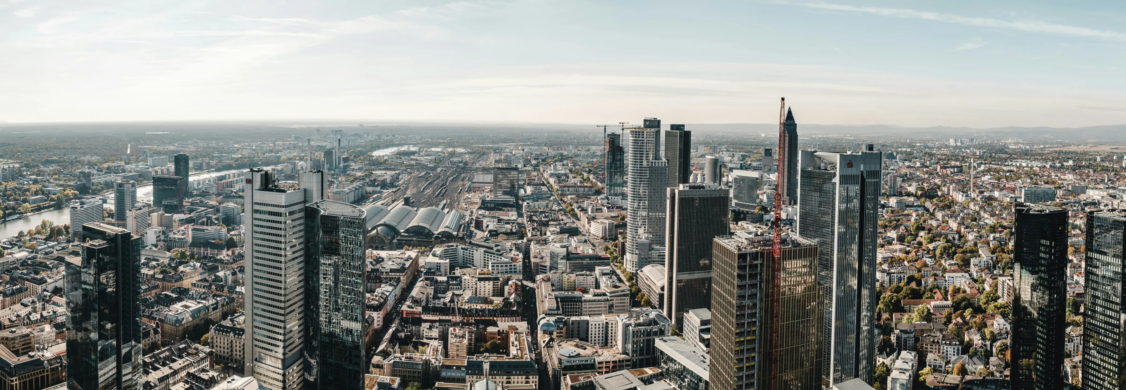 Weites Frankfurt-Panorama von oben mit Hochhäusern, Hauptbahnhof und Main